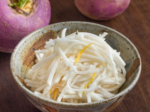 A 2 part image showing peeled turnips being sliced on a mandoline