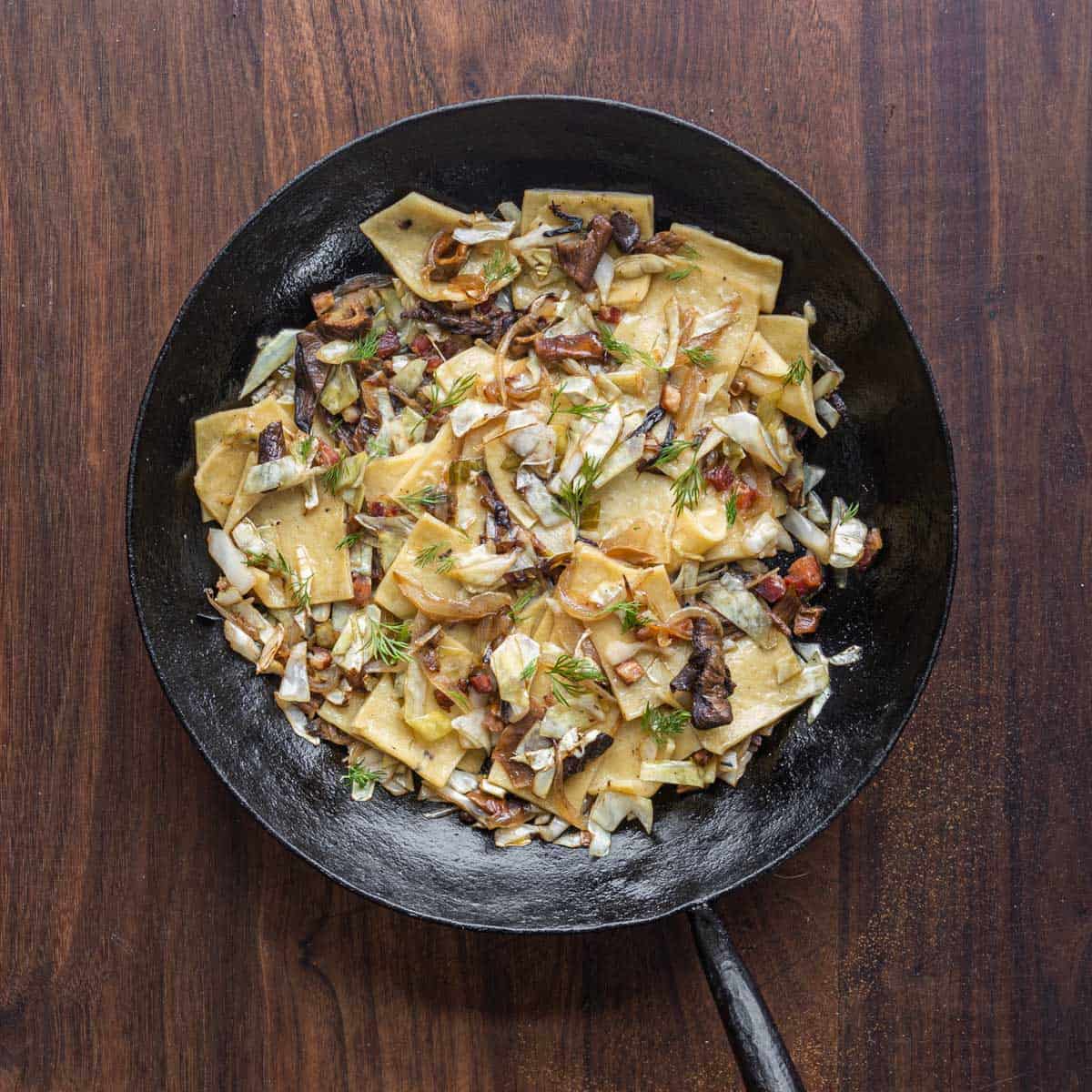 pasta with cabbage, onions, bacon and porcini mushrooms in a carbon steel pan 
