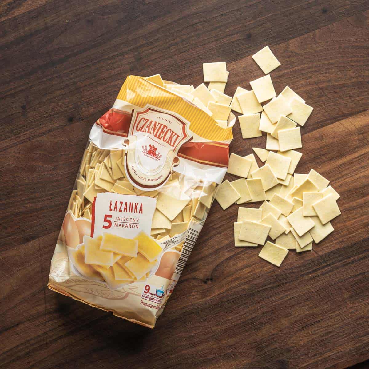 a bag of polish lazanki pasta, the bag cut open and square pasta laid out.