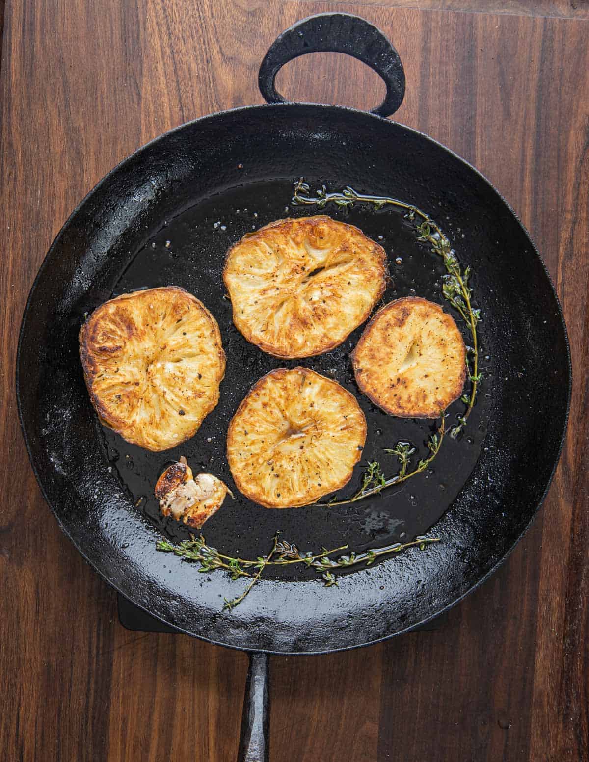 roasted celeriac steaks in a carbon steel pan 