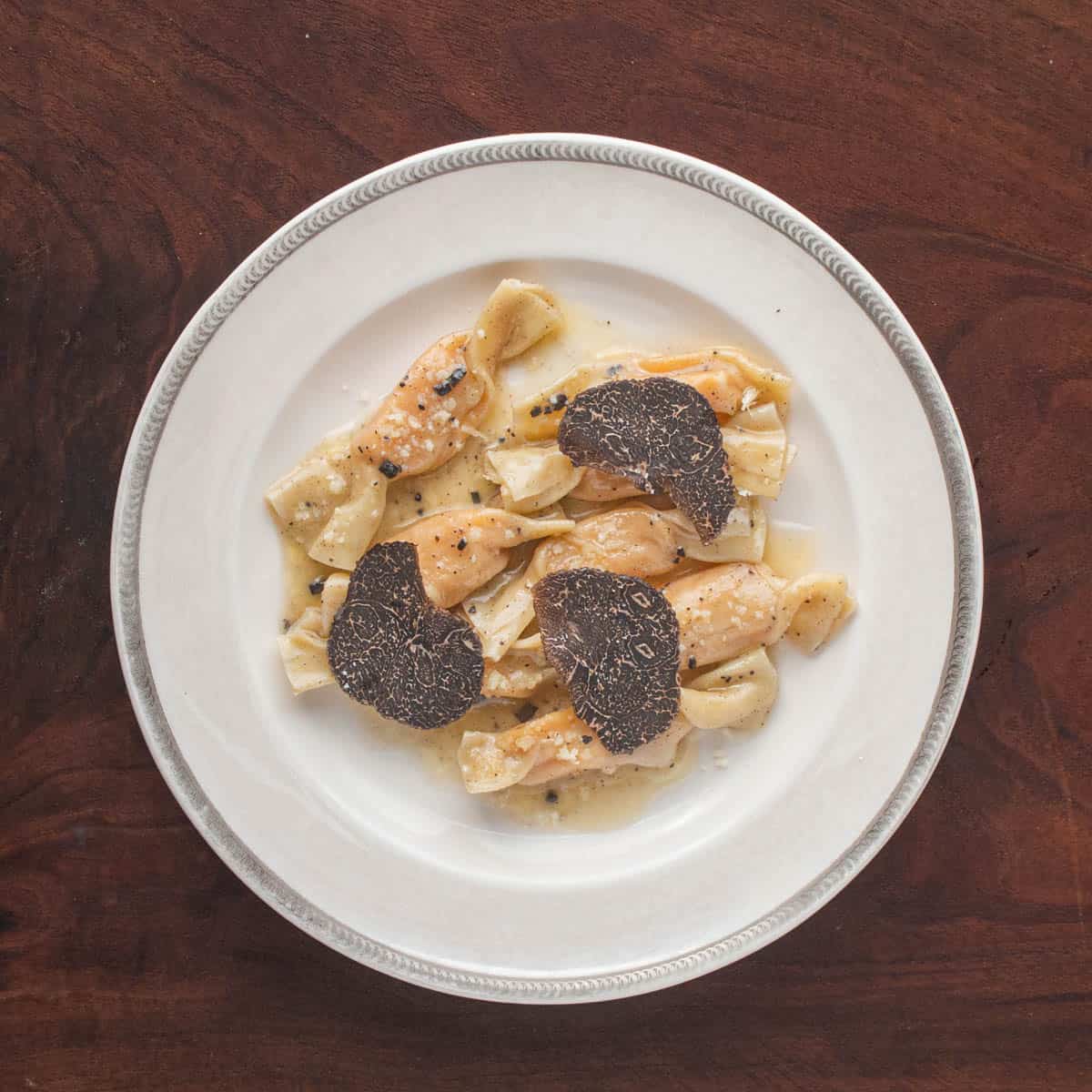 a plate of squash caramelle pasta with truffle butter sauce.