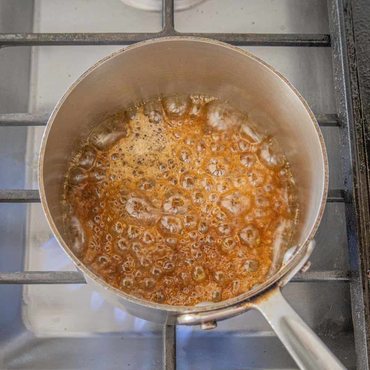 Boiling maple syrup in a pan on the stove.