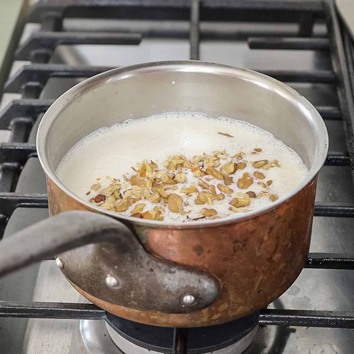 heating black walnuts with ice cream base in a copper pan.