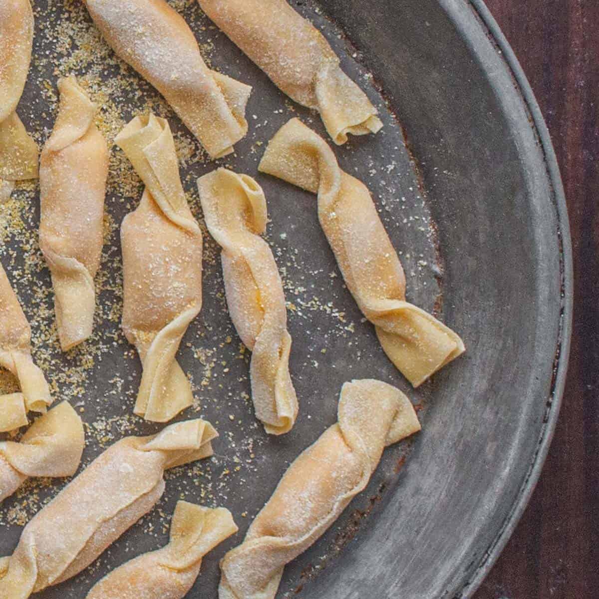 Caramelle pasta on a tray dusted with cornmeal