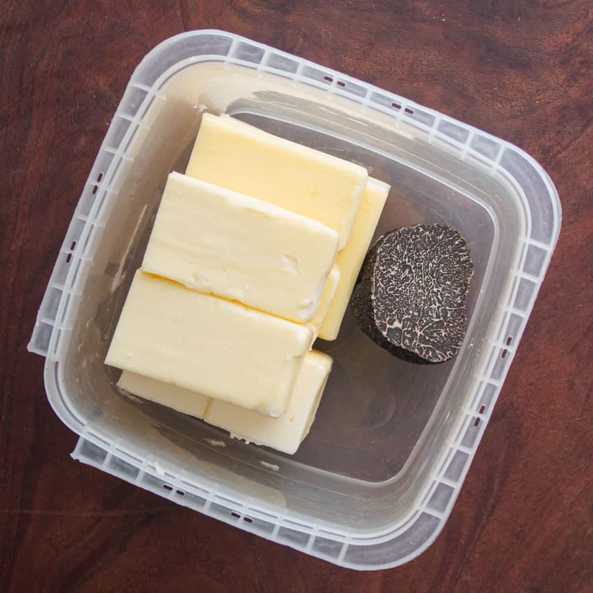 Storing butter in a deli container with fresh truffles. 