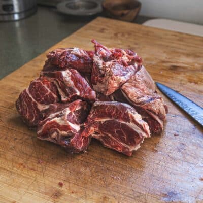 Cutting lamb neck into stew pieces. 