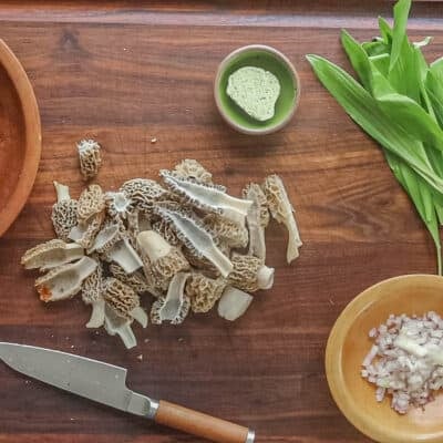 Cutting morel mushrooms on a cutting board. 