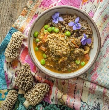 Mushroom Matar or Mutter mushroom peas curry in a bowl surrounded by gucchi mushrooms.