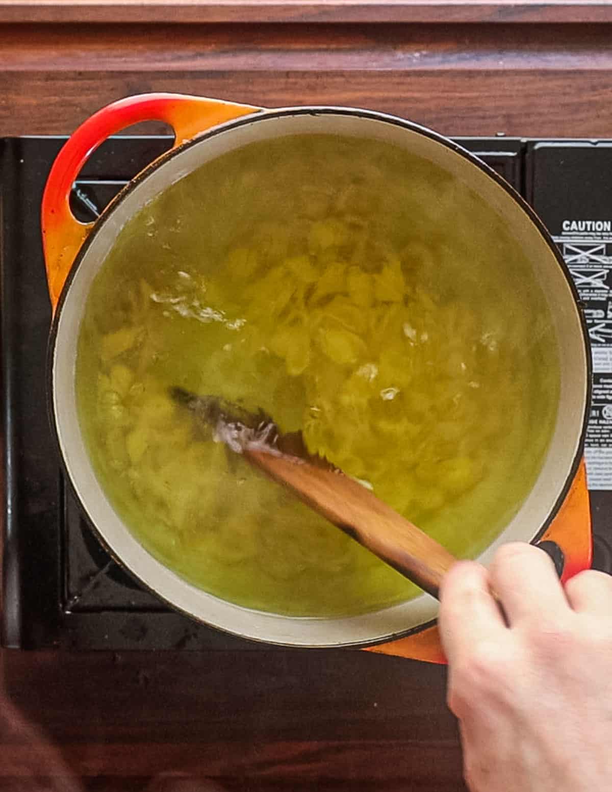 Stirring orechiette pasta to prevent sticking.