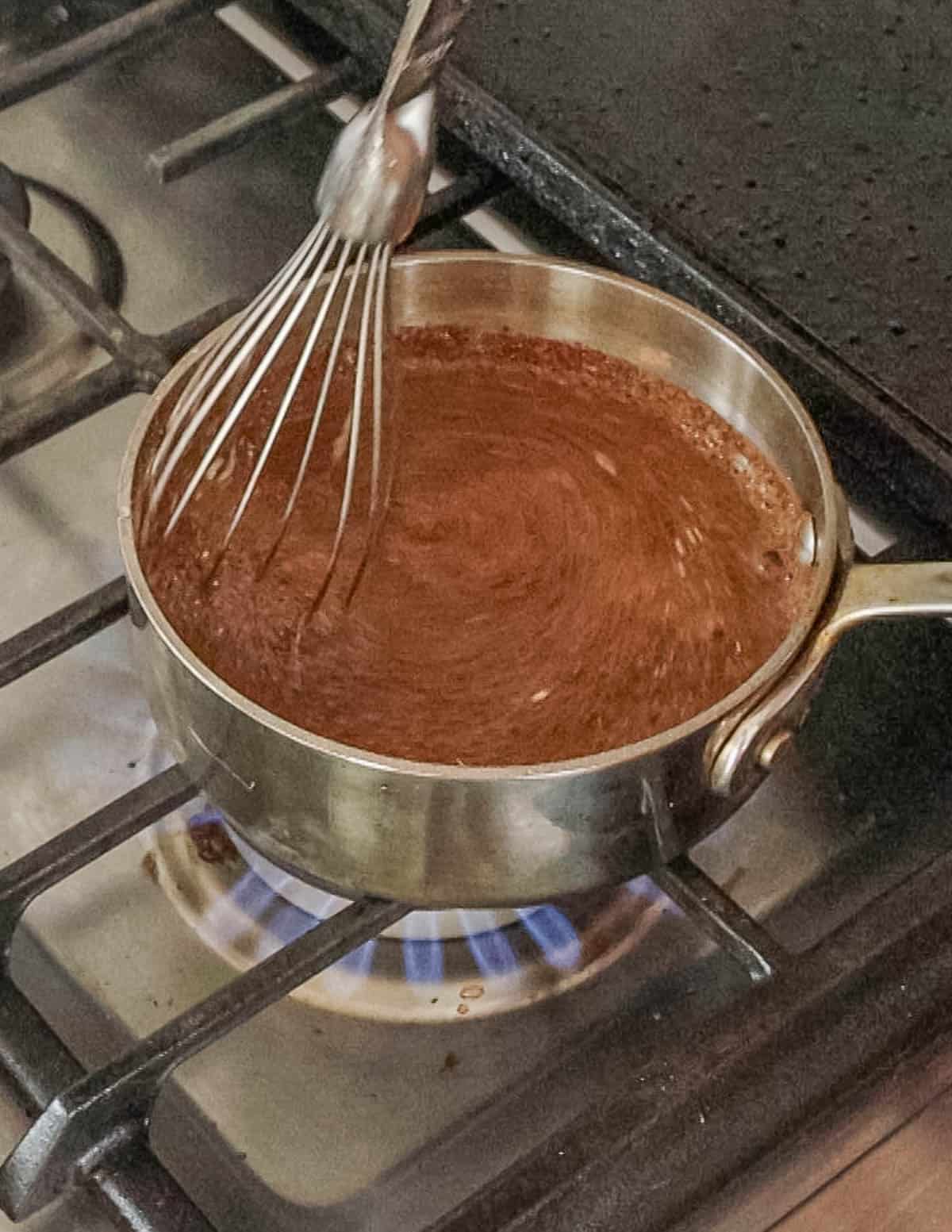 Whisking a small pan of dock seed flour and acorn starch.