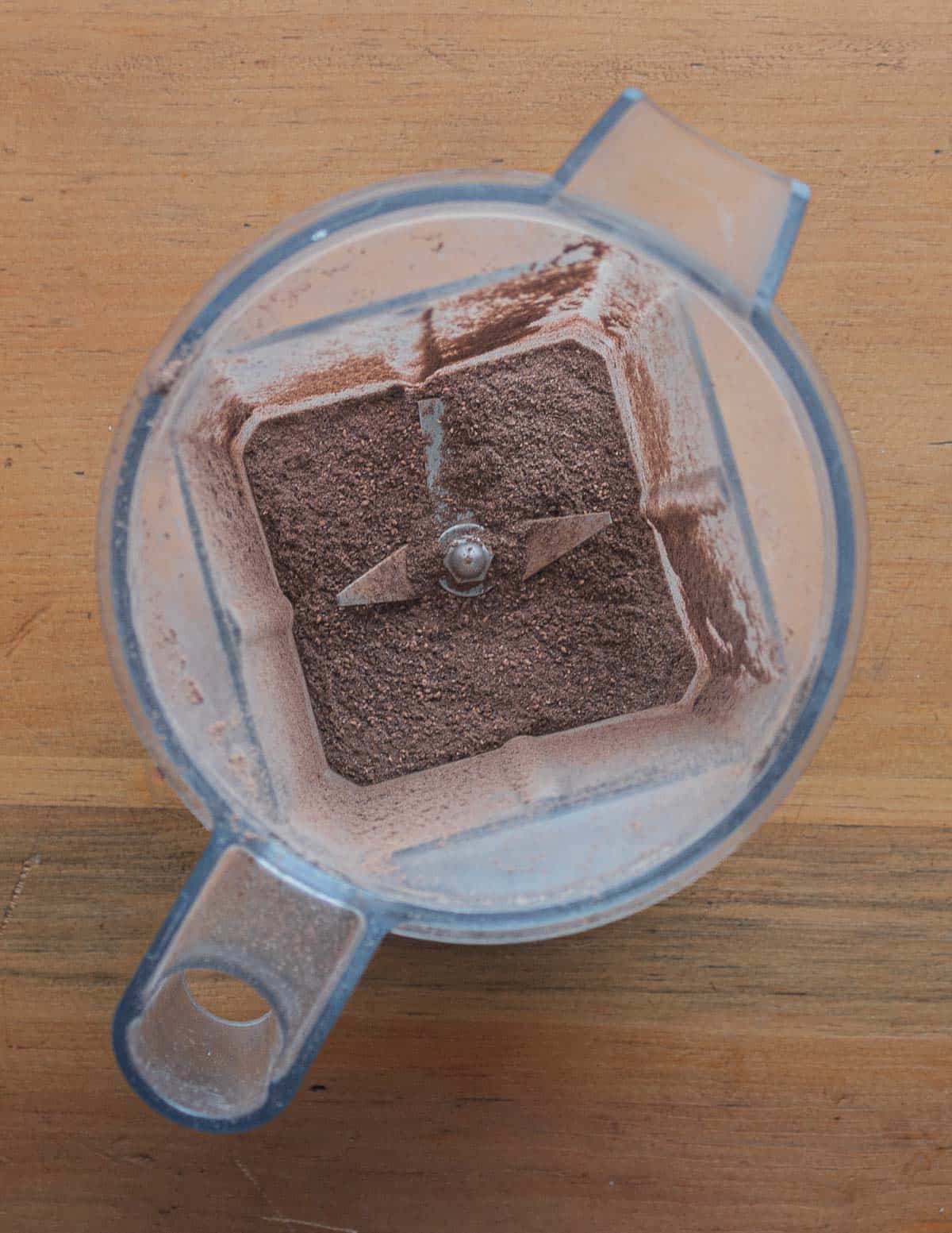 Ground dock flour in the bowl of a vitamix blender.