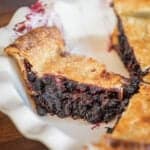A picture of cutting slices of fresh mulberry pie.