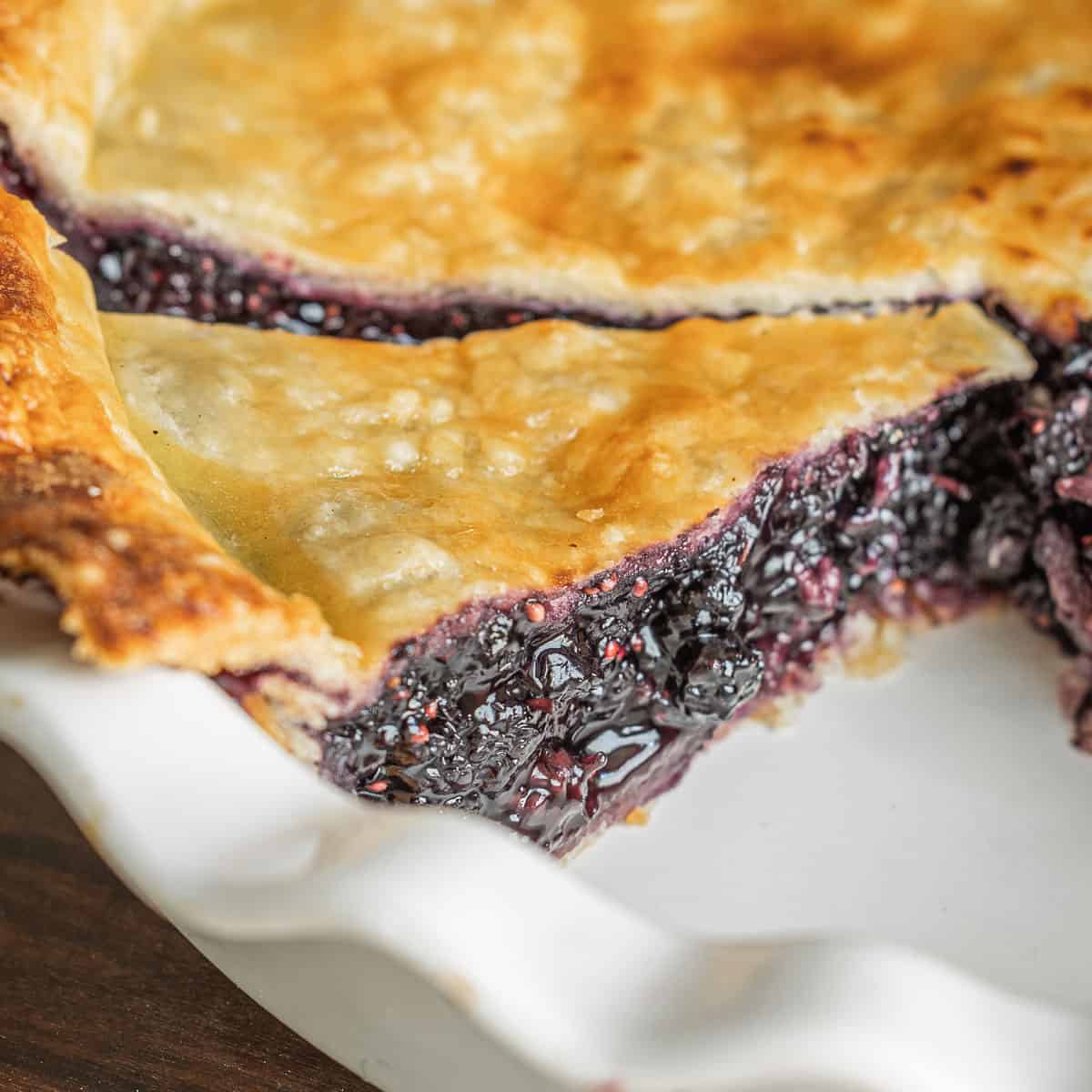 A close up image of mulberry pie in a pie pan.