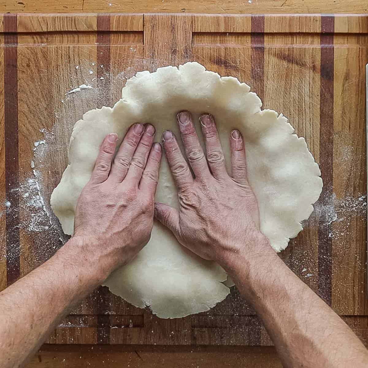 Placing a pie crust in a pie pan. 