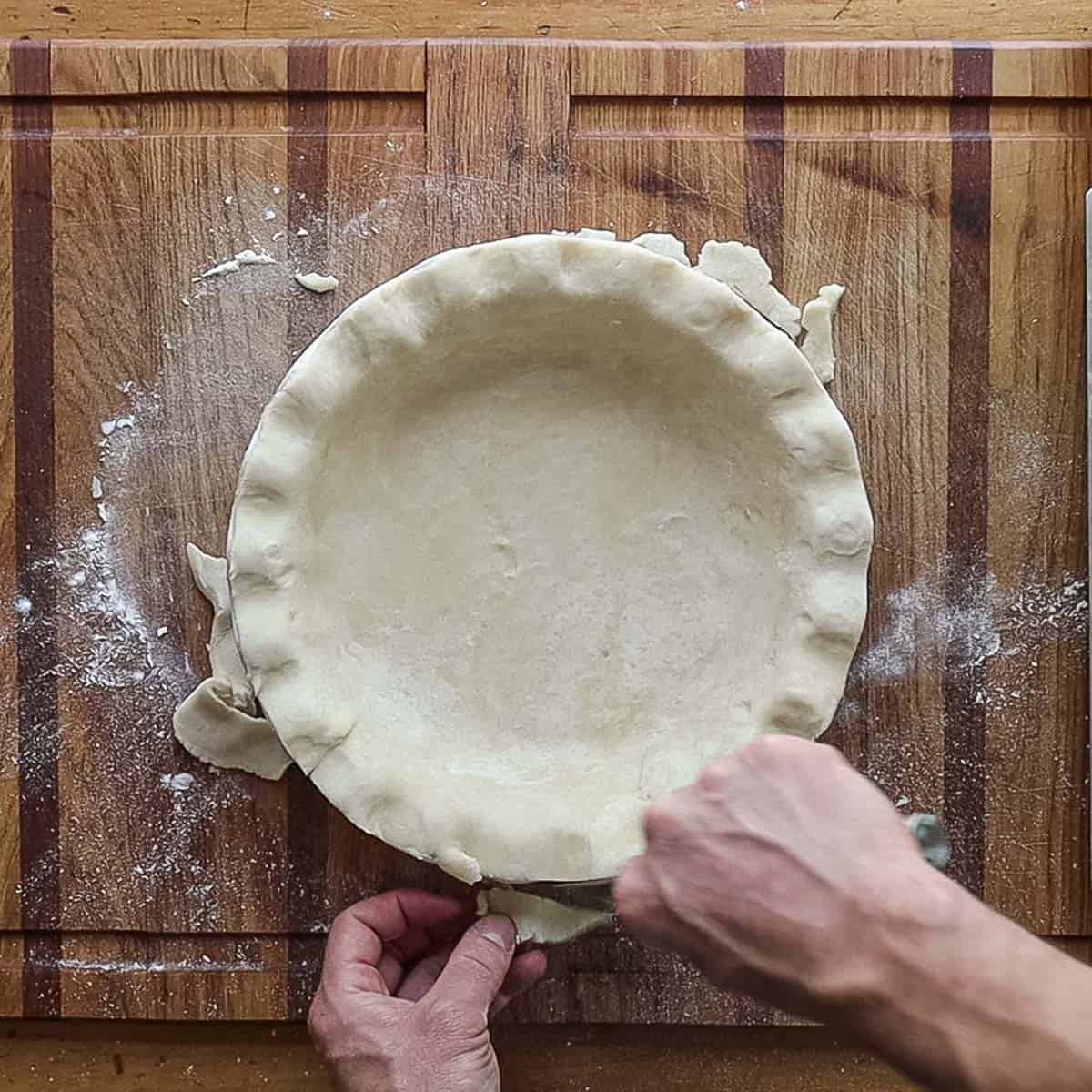 Trimming the edges of a pie pan to make mulberry pie. 