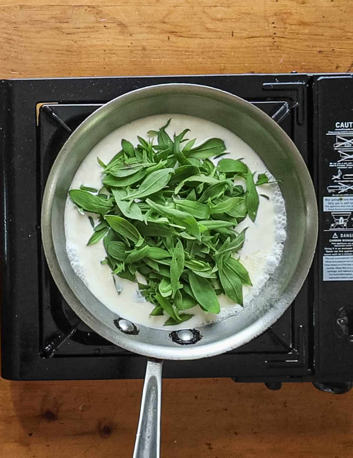 Adding sorrel leaves to a reduction sauce. 