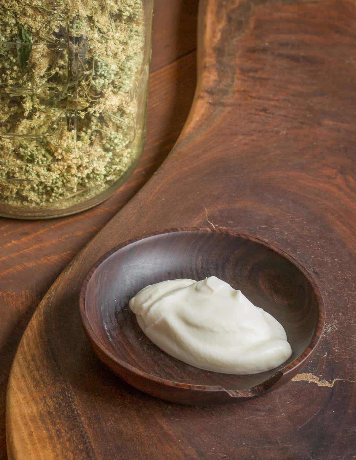 Dried meadowsweet flowers in a jar next to meadowsweet creme fraiche. 