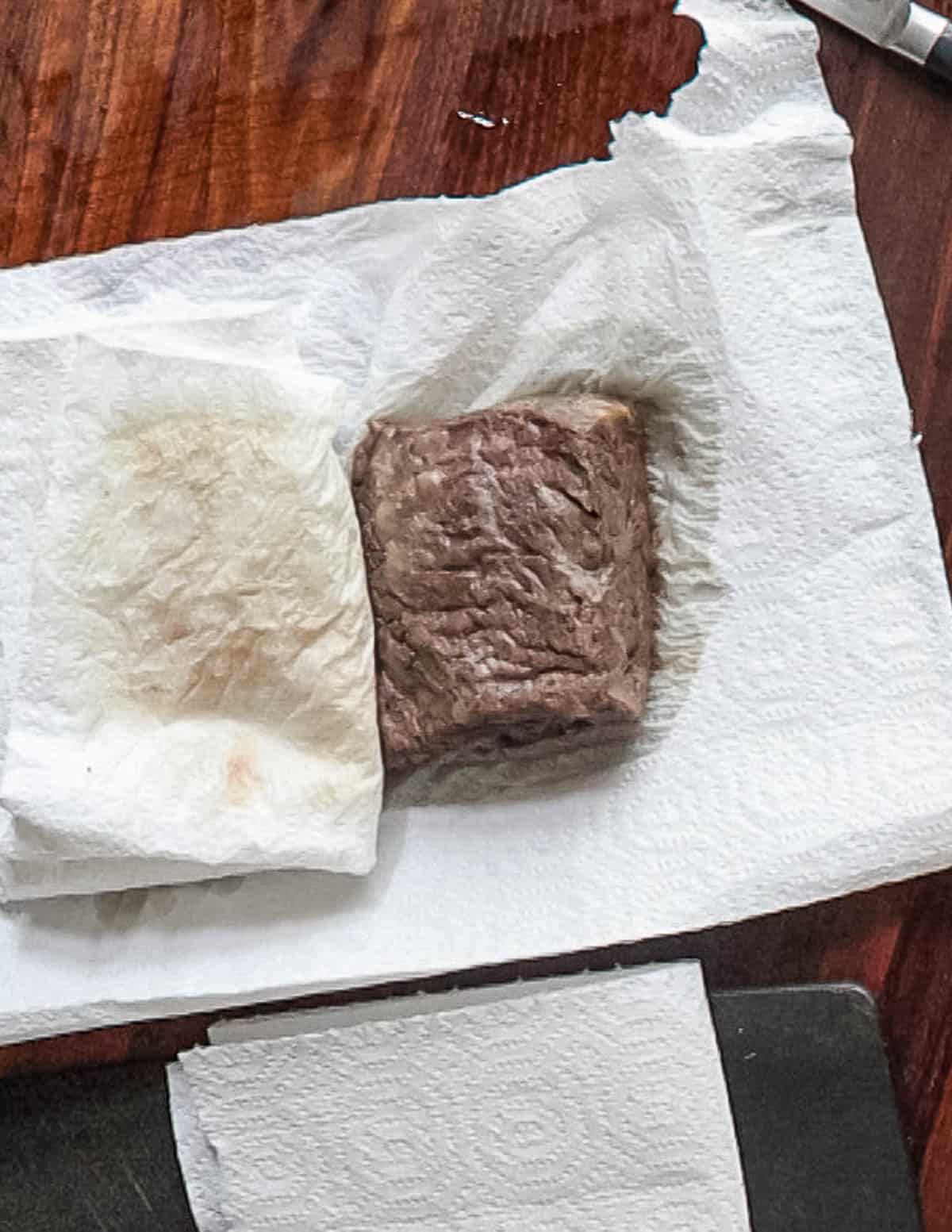 Letting a steak rest on paper towels before slicing.