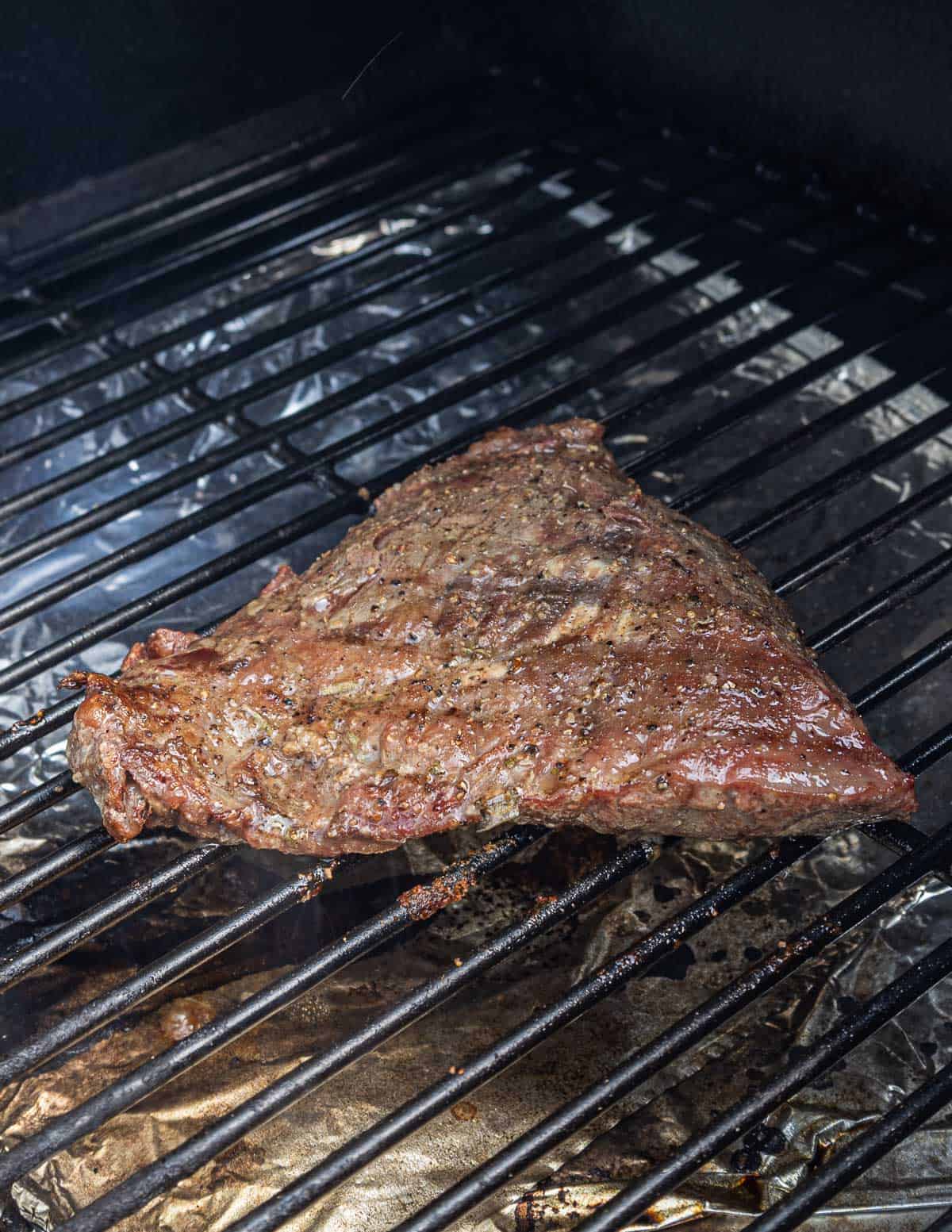 Cooking a bavette steak on a grill.