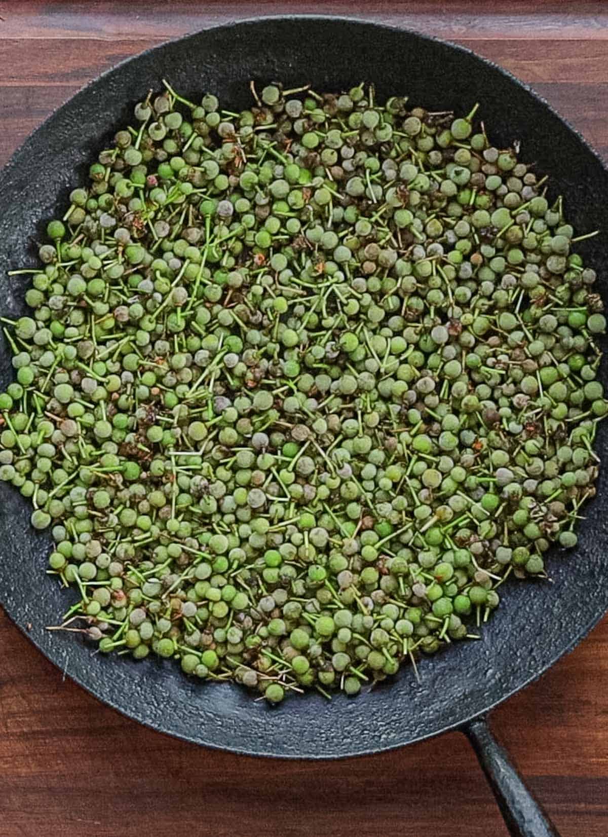 Green linden seeds in a carbon steel pan. 