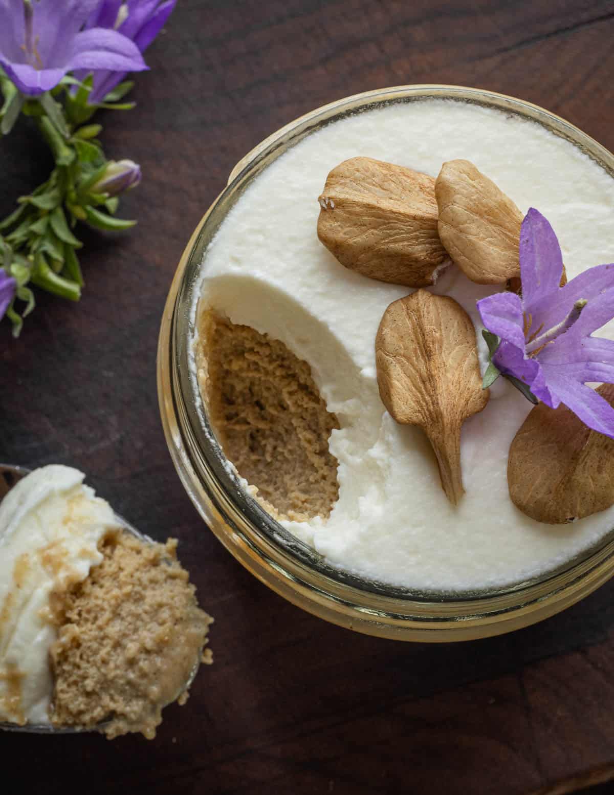 Top down image of Linden seed custard garnished with fresh butternuts or white walnuts, whipped cream and bellflowers.
