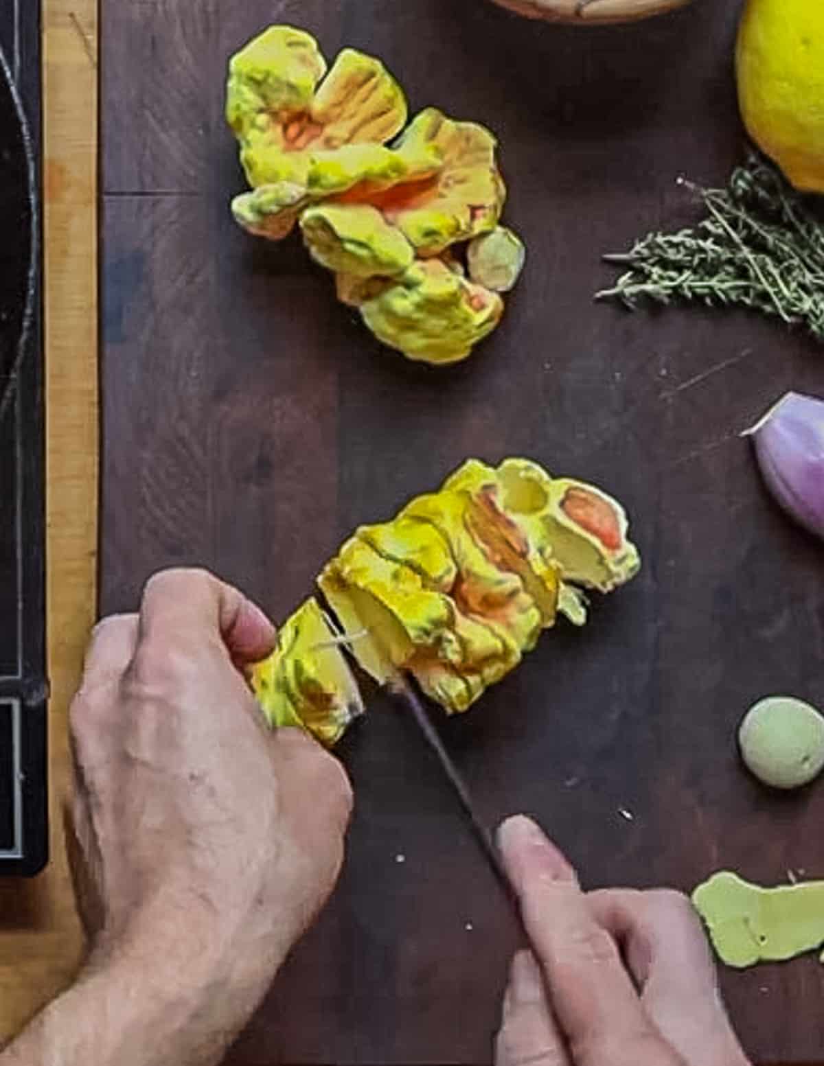 Slicing a chicken of the woods mushroom with a petty knife. 