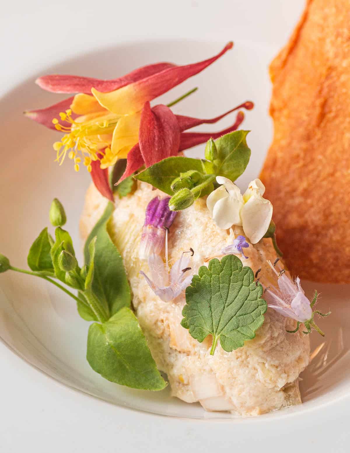 A close up image of a trout salad with wild flowers.