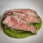 Grilled, sliced bavette steak with salsa verde sauce.