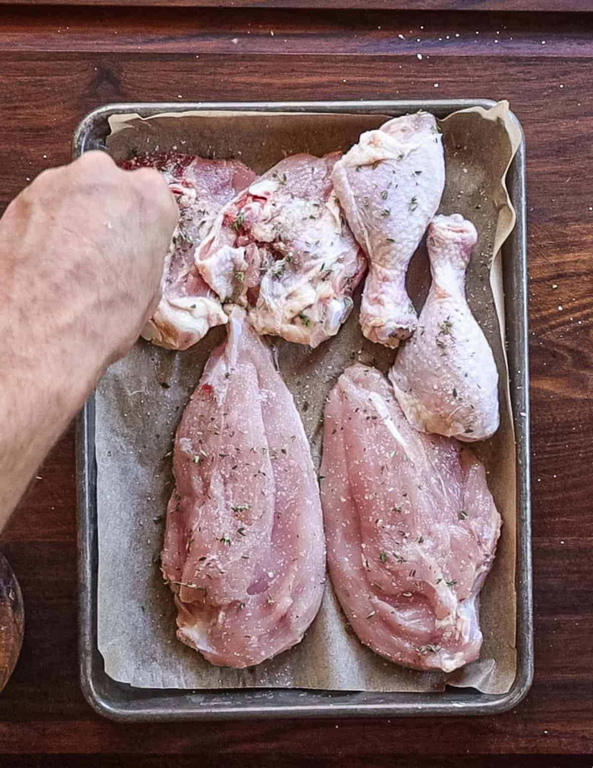 Seasoning chicken pieces with salt, pepper and fresh thyme. 