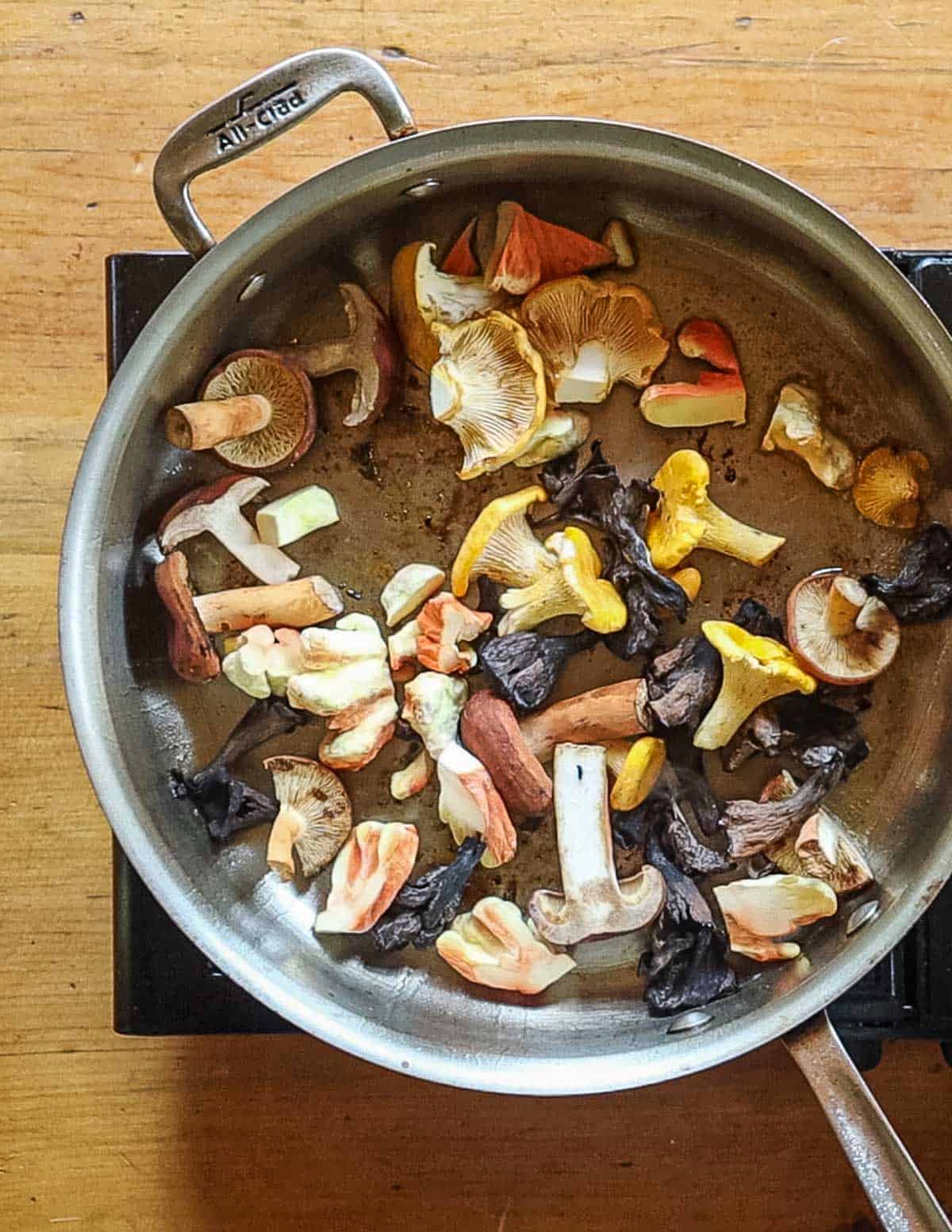 Adding wild mushrooms to a pan chicken was cooked in. 