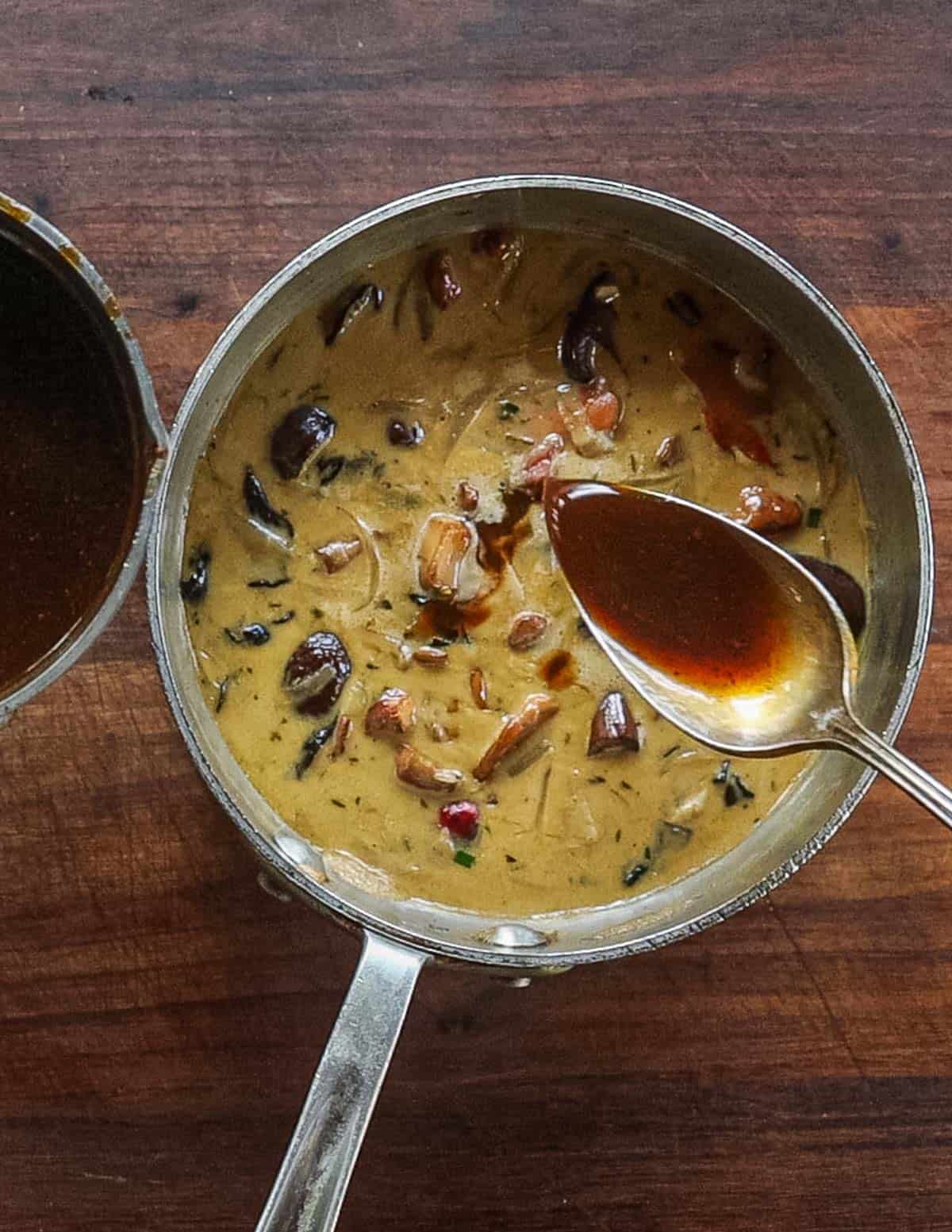 Adding demi glace to a pan of mushroom forestiere sauce. 