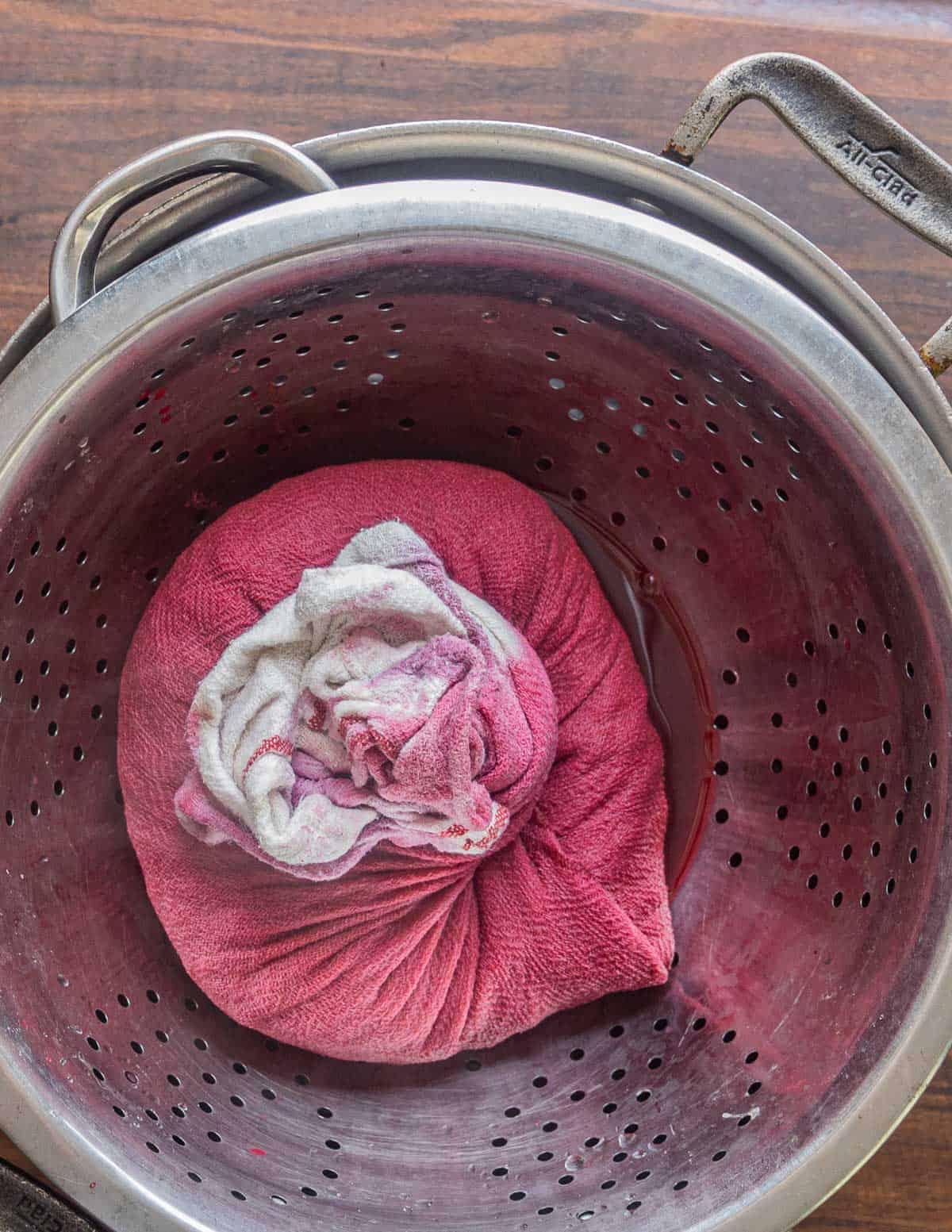 Straining cherry juice in a colander. 