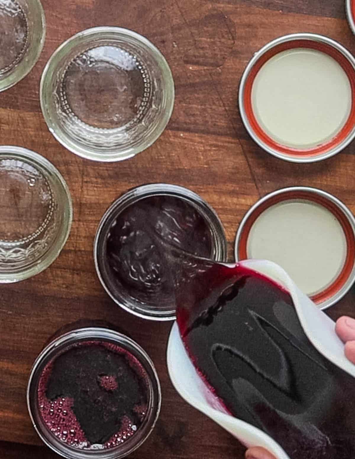 Pouring chokecherry syrup into mason jars for canning. 