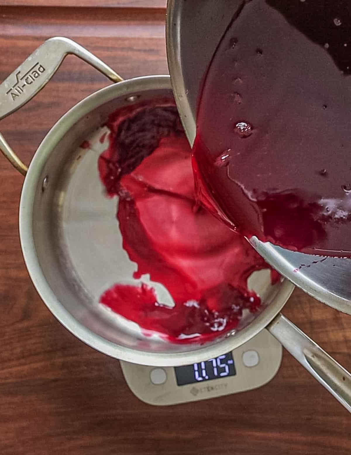 Pouring strained chokecherry juice into a pot. 