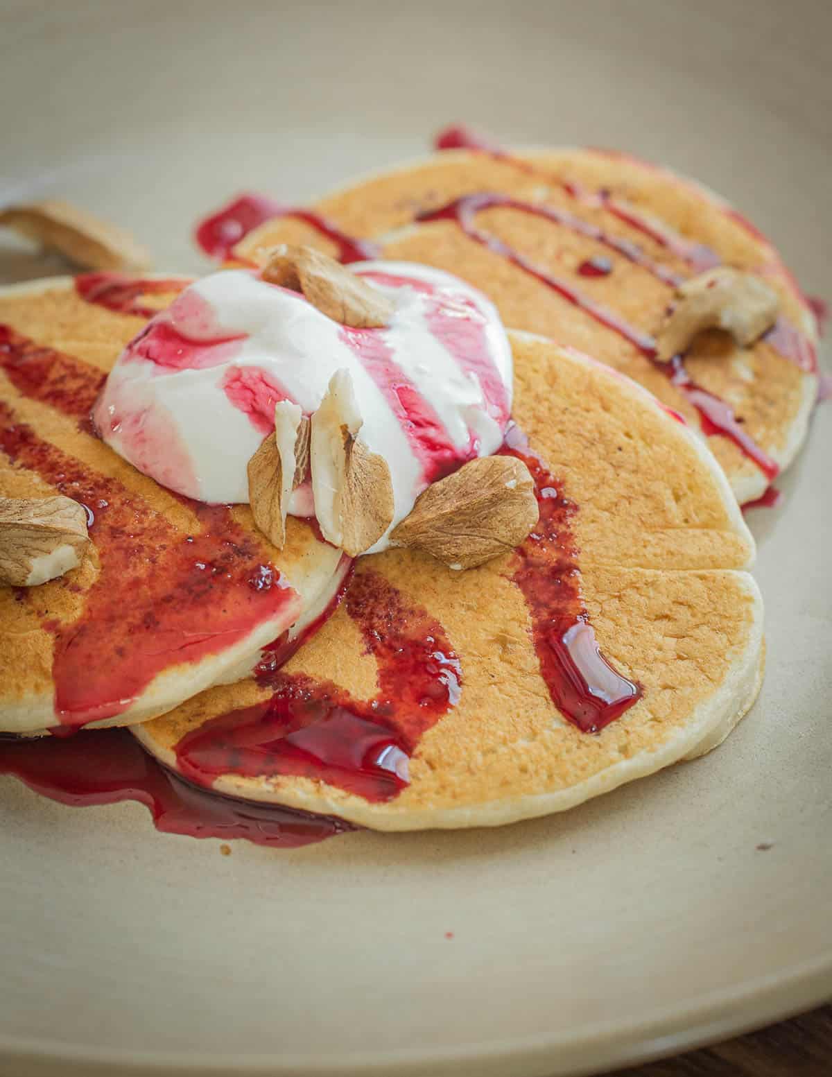 Fresh pancakes drizzled with wild cherry syrup, yogurt and butternuts. 