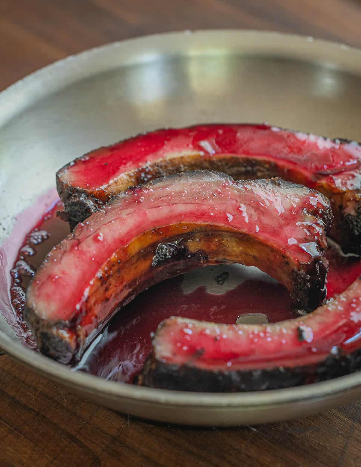 Pork ribs in a pan glazed with cherry syrup. 