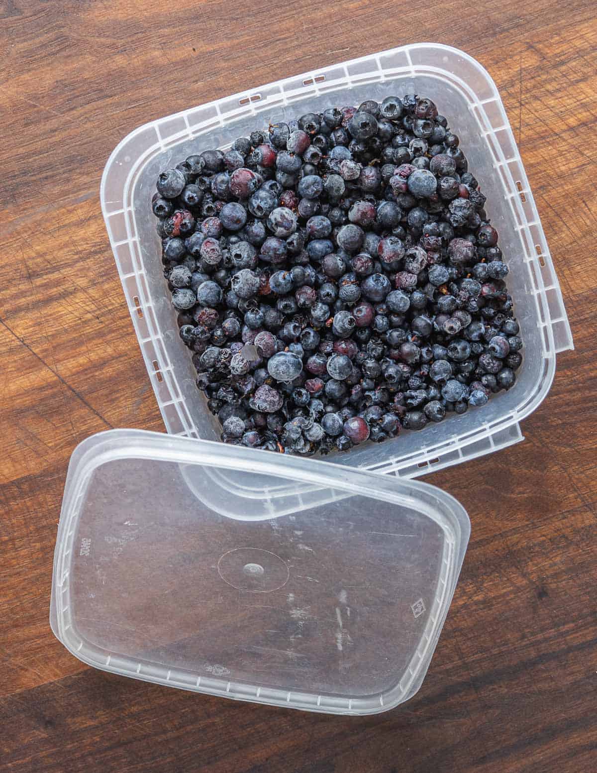 Frozen wild blueberries in a tupperware container. 