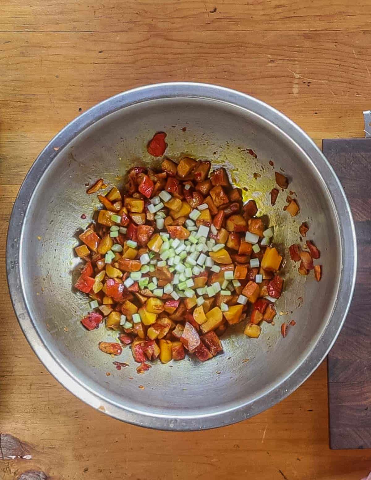 Adding diced celery to a mushroom salad in a bowl. 