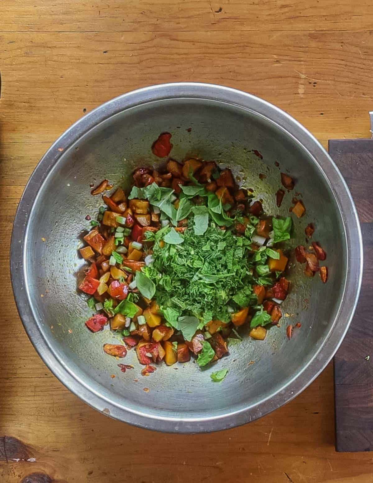 Adding chopped herbs to mushroom salad in a bowl. 