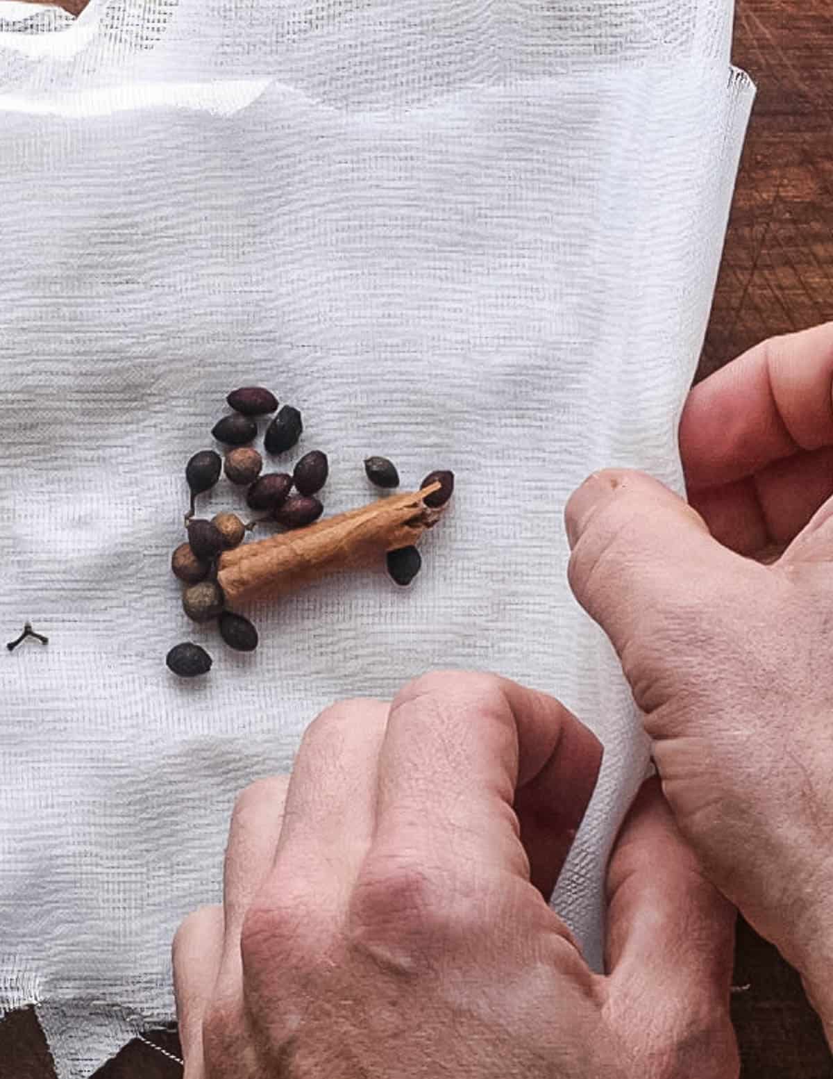 Wrapping cinnamon, spicebush and allspice into cheesecloth.