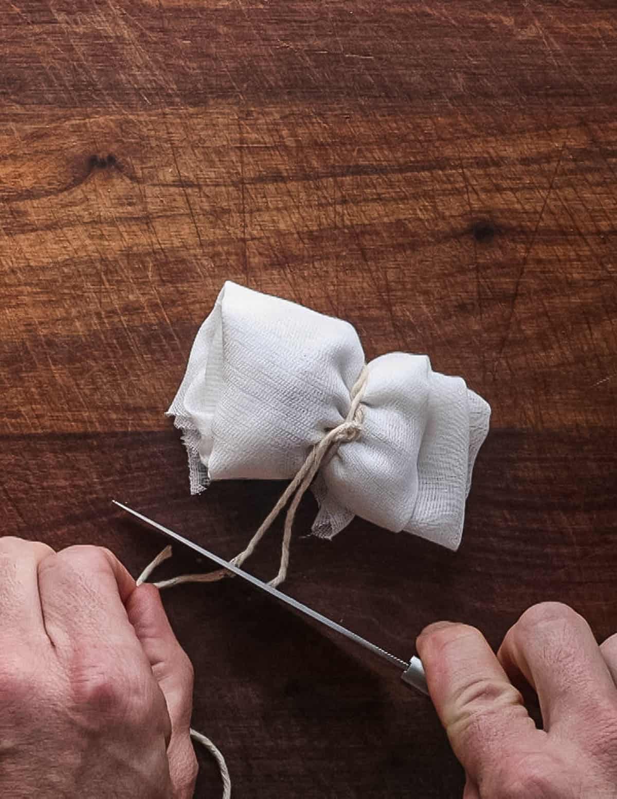 Cutting twine on a bundle of cheesecloth.