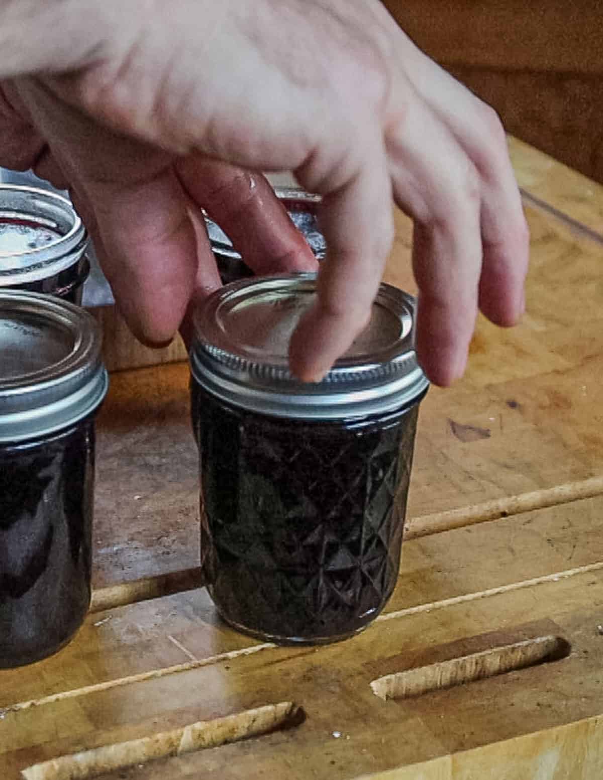 Sealing jars of preserves with a lid. 
