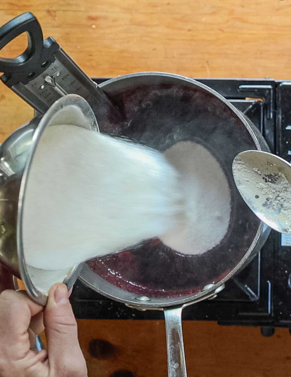 Adding sugar to aronia juice. 