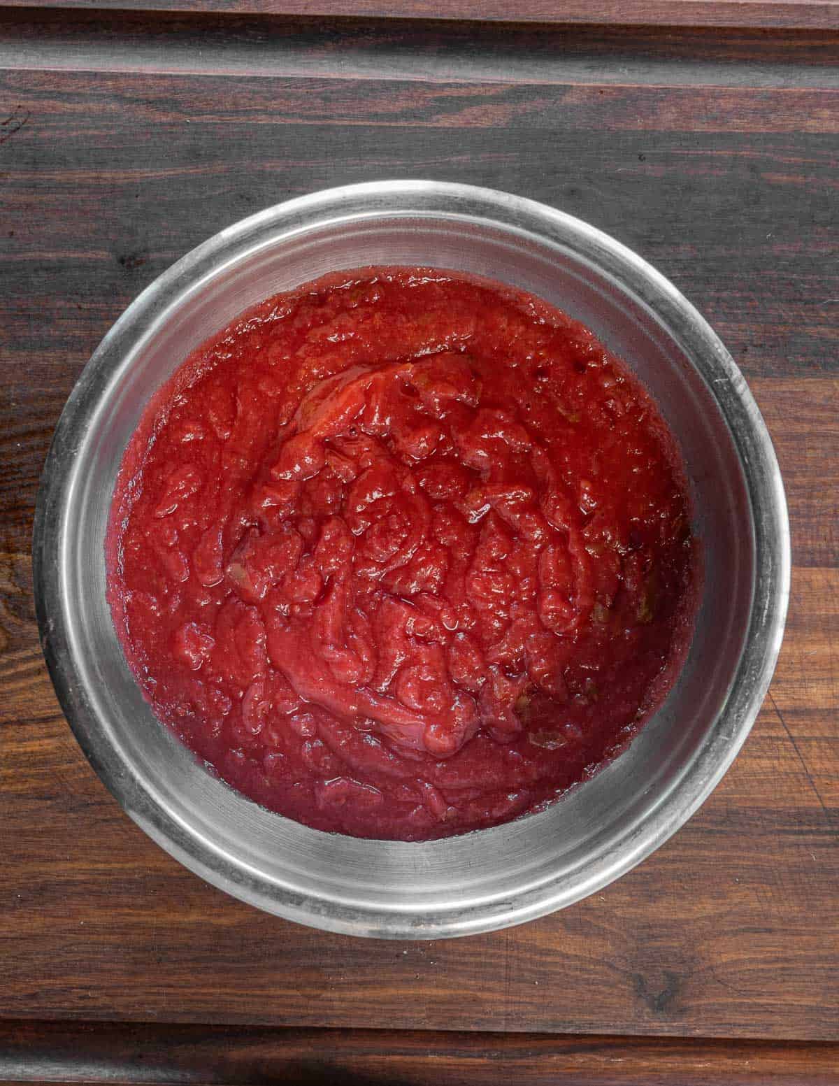 A bowl of red crab apple sauce.