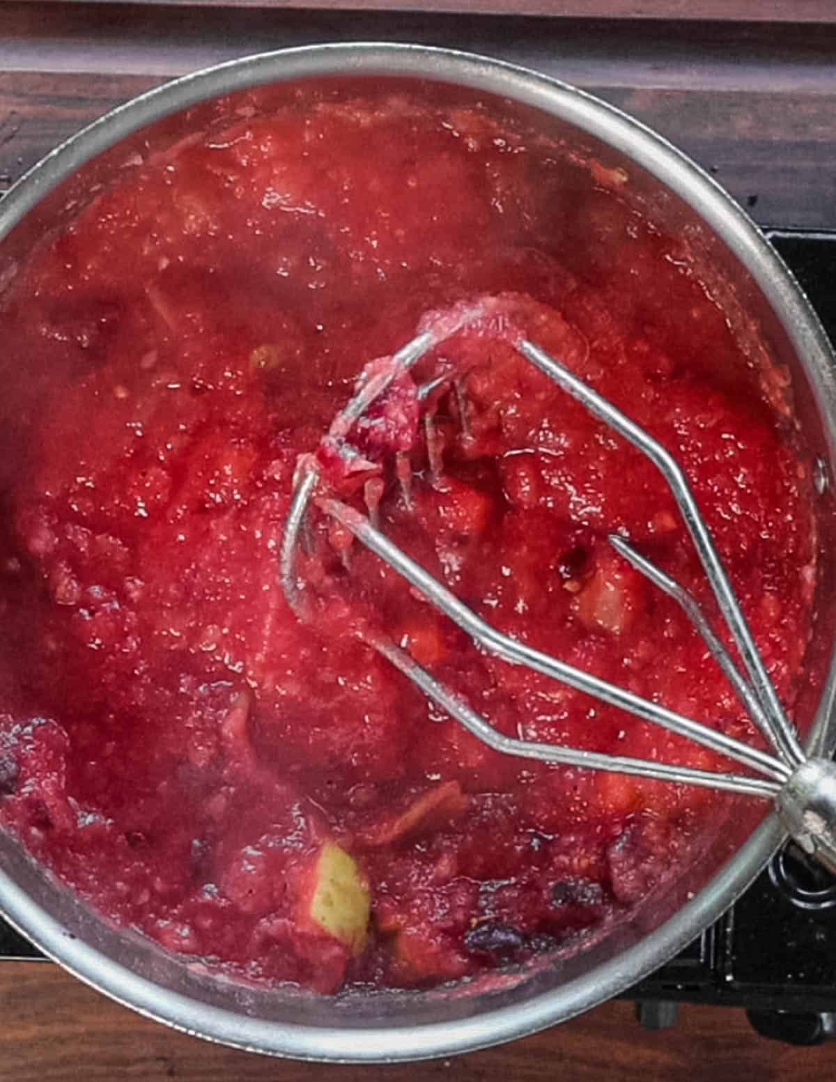 Mashing crab apples in a pot. 