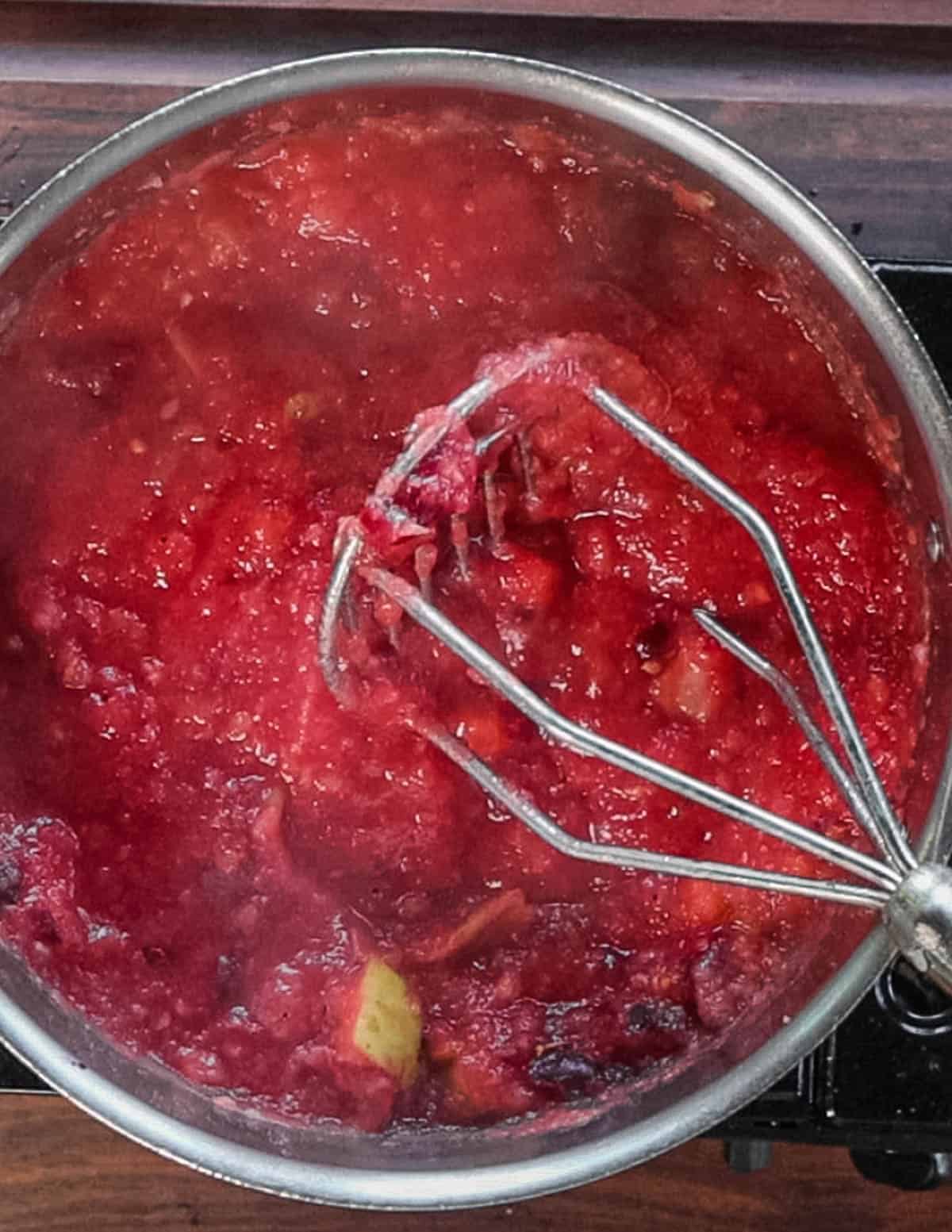 Mashing crab apples in a pot.