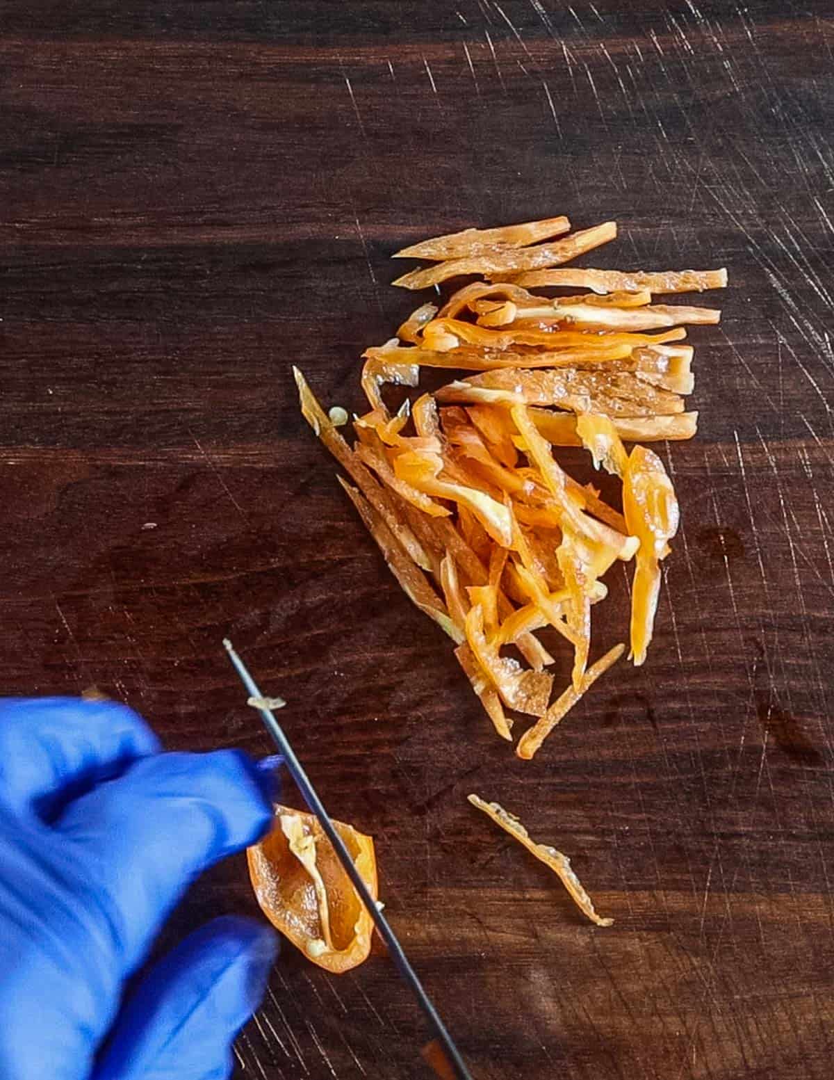 Cutting hot habanero peppers into strips. 