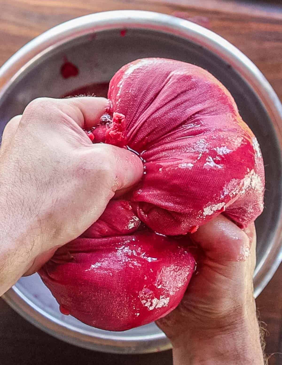 Squeezing juice from a bag of cooked apples. 