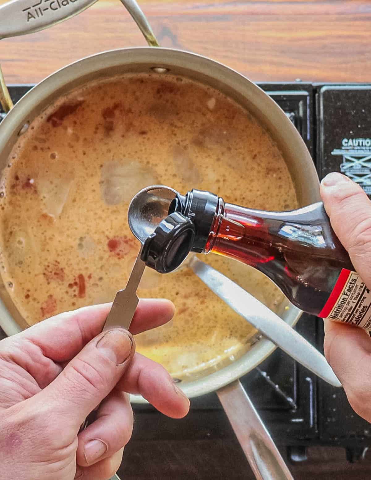 Adding fish sauce to a pot of thai mushroom soup. 