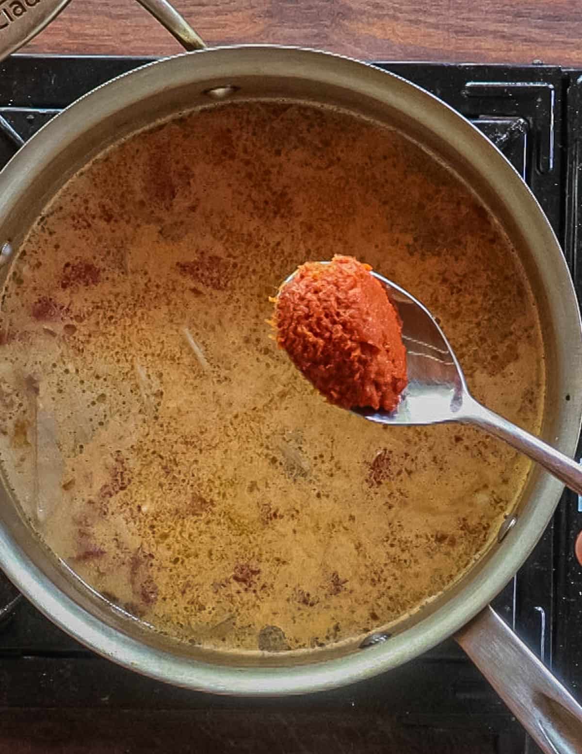 Adding Thai chili paste or curry paste to soup. 